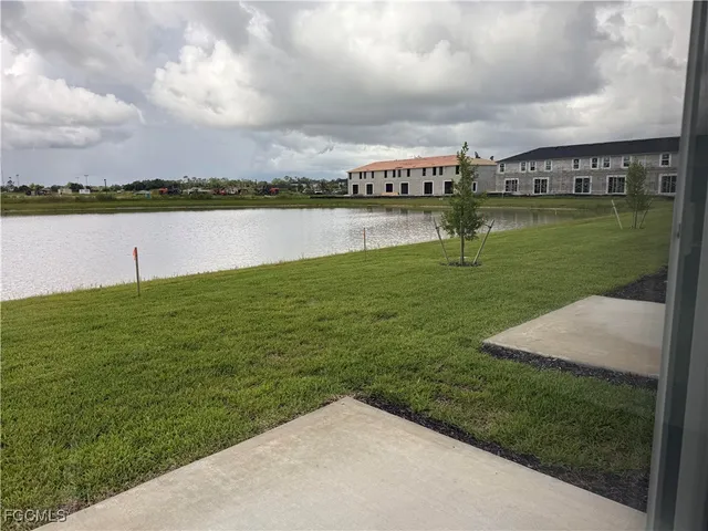 a view of a lake with a big yard and large trees