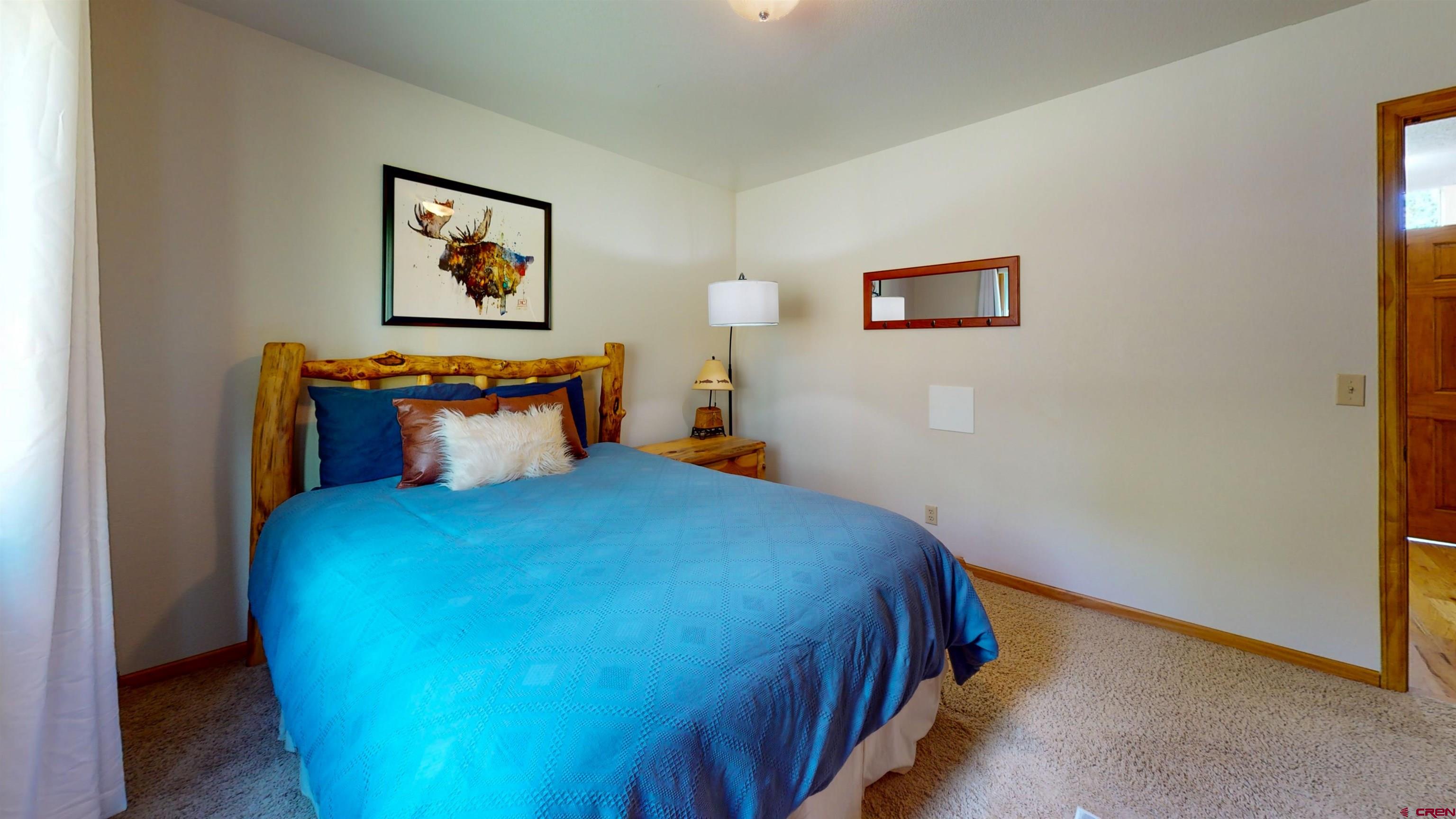 261 Aspen Drive Durango, CO 81301 - Photo 23 of 34 a bedroom with a bed and painting on the wall