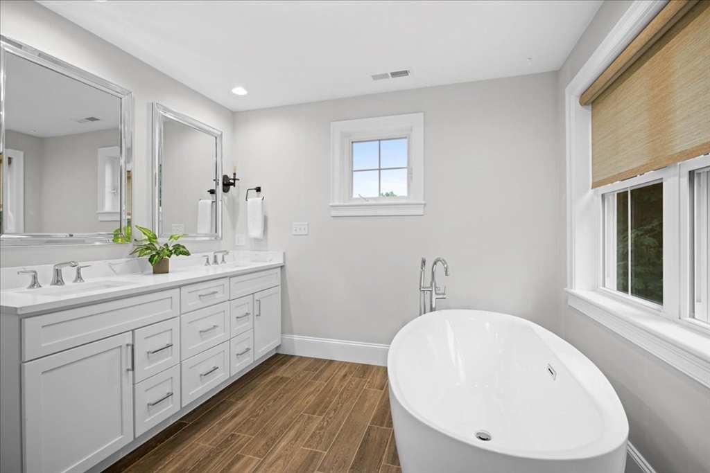 11 Waring Road Natick, MA 01760 - Photo 21 of 41 a bathroom with a double vanity sink a mirror and a bathtub