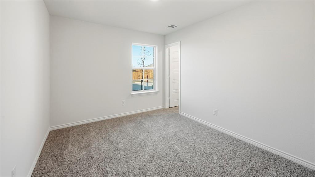 419 Epiphany Lane Lavon, TX 75166 - Photo 22 of 31 Carpeted room with white walls, a single window, and a white paneled door