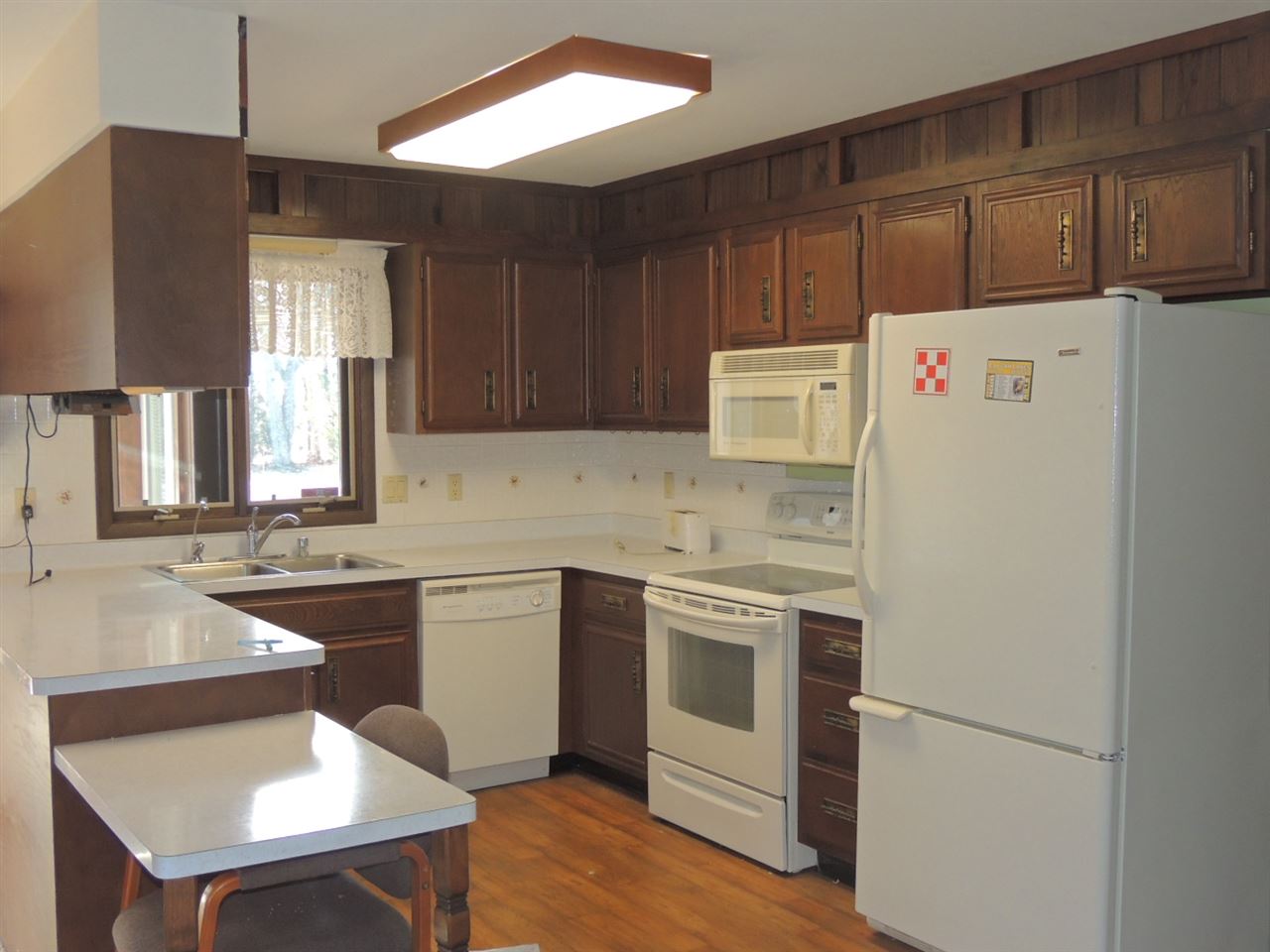 8344 South Schroeder Road Clinton, WI 53525 - Photo 18 of 25 a kitchen with a sink a stove a refrigerator and white cabinets