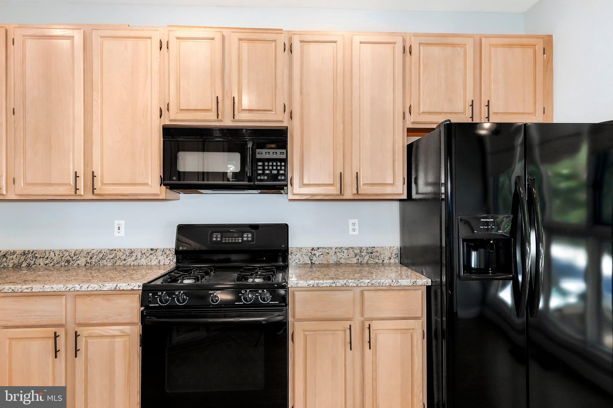 106 Lancefield Road Baltimore, MD 21209 - Photo 12 of 37 a kitchen with stainless steel appliances wooden cabinets and a stove top oven
