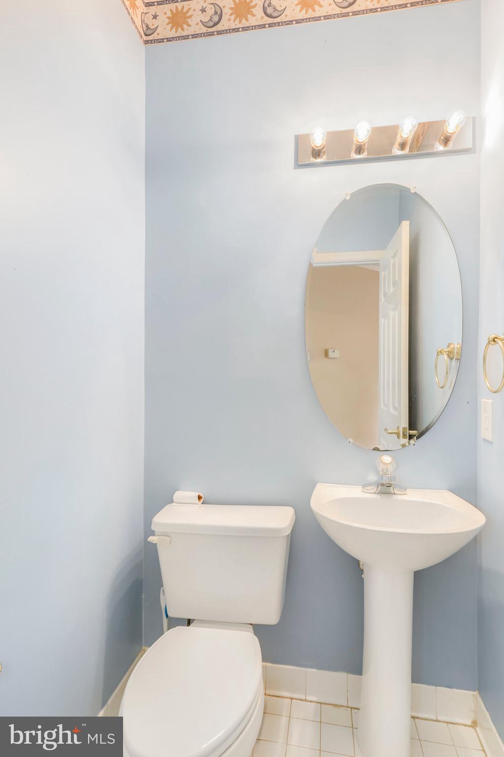 106 Lancefield Road Baltimore, MD 21209 - Photo 16 of 37 a bathroom with a toilet sink and mirror