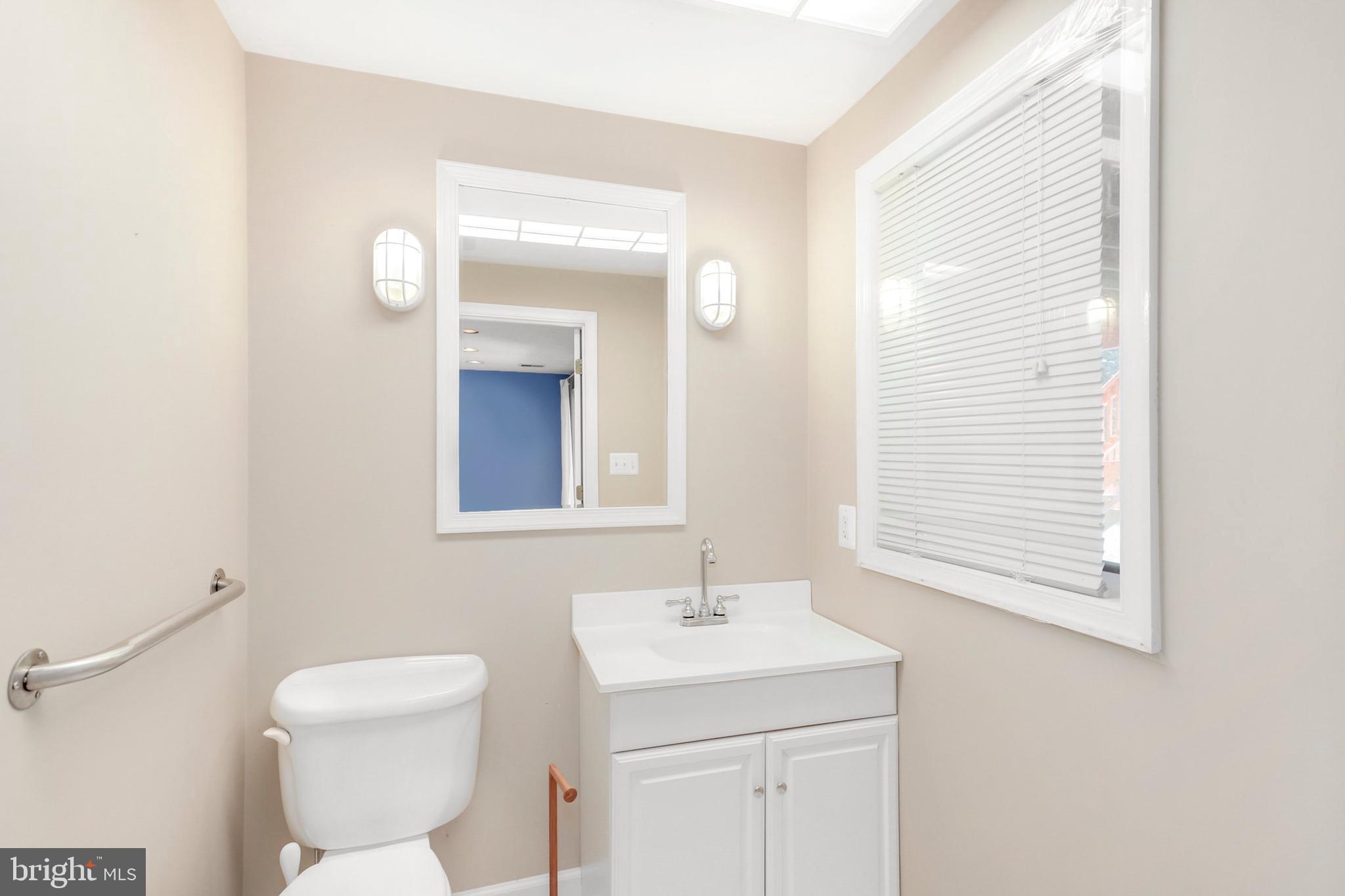 106 Lancefield Road Baltimore, MD 21209 - Photo 30 of 37 a bathroom with a toilet a sink and mirror