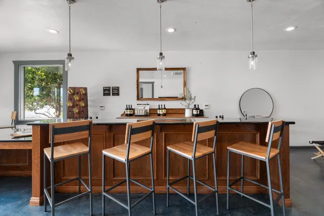 an open kitchen with granite countertop a sink dishwasher a dining table and chairs with wooden floor