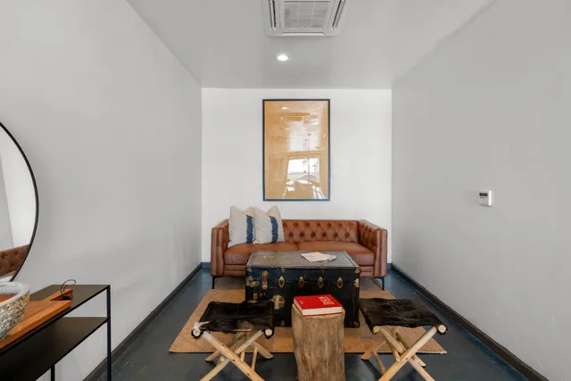 a room with lots of white furniture and a chandelier