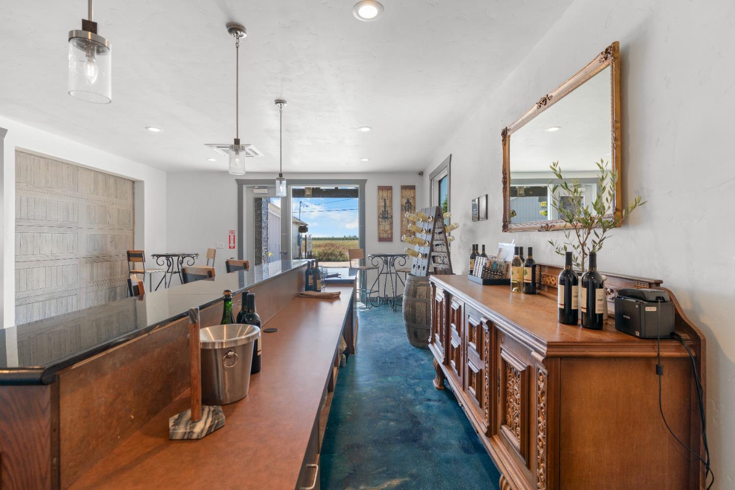 6539 East Peltier Road Acampo, CA 95220 - Photo 16 of 70 a view of a kitchen with kitchen island stainless steel appliances a refrigerator a sink dishwasher a stove and a dining table with wooden floor
