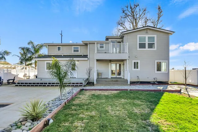 a view of a house with a big yard and large trees