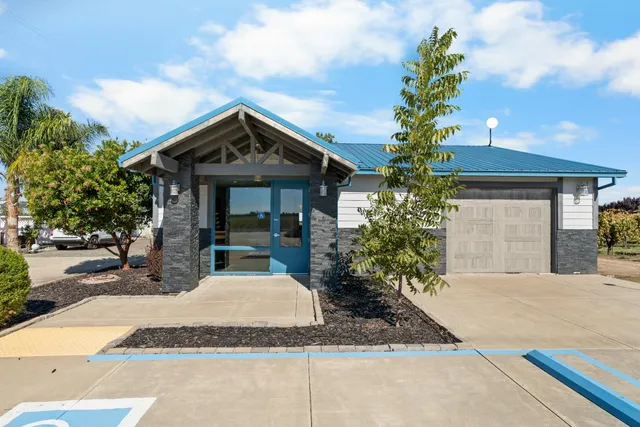 a kitchen with stainless steel appliances granite countertop a table chairs and a refrigerator