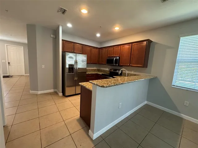 a kitchen with kitchen island granite countertop a stove a sink and a refrigerator