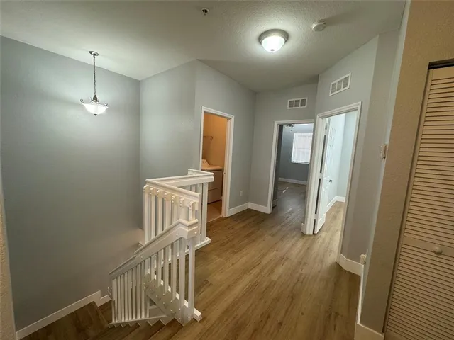 a view of a hallway with wooden floor