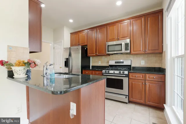 a kitchen with stainless steel appliances granite countertop a stove microwave sink and refrigerator