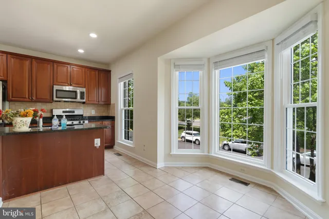 a kitchen with stainless steel appliances granite countertop a refrigerator oven a sink with granite countertops and a view of window