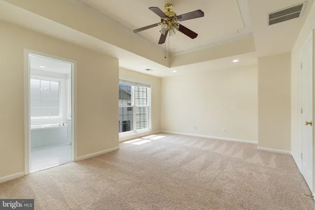 a view of empty room with wooden floor and ceiling fan