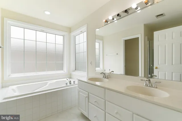 a bathroom with a large tub sink and mirror