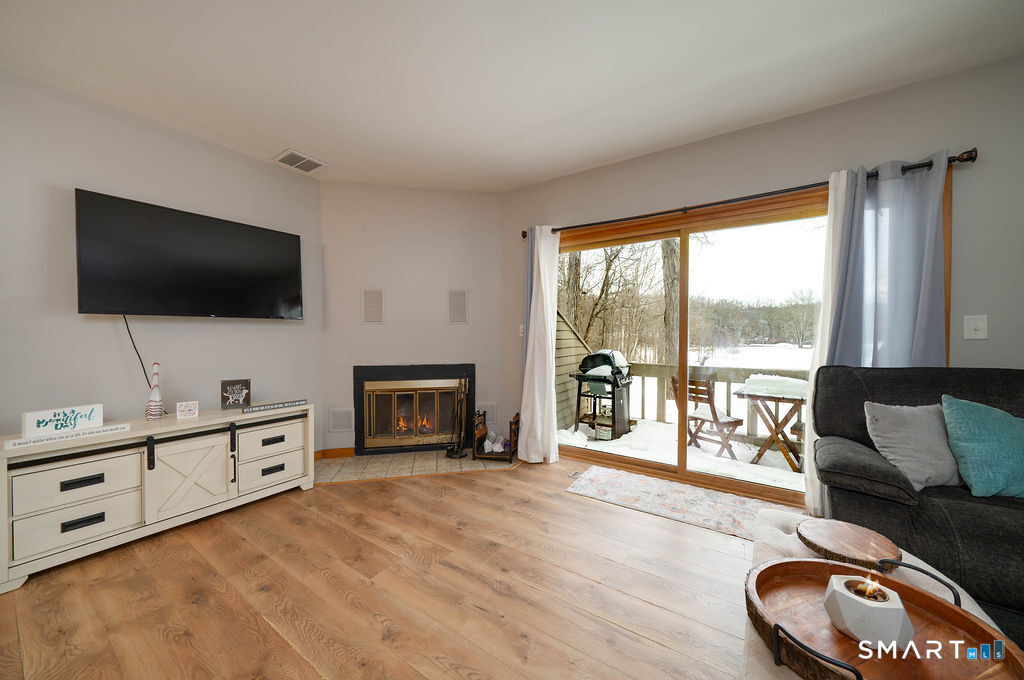 219 Twin Lakes Road, Unit A North Branford, CT 06471 - Photo 4 of 33 Large living room with fireplace, and view of the golf course, deck access