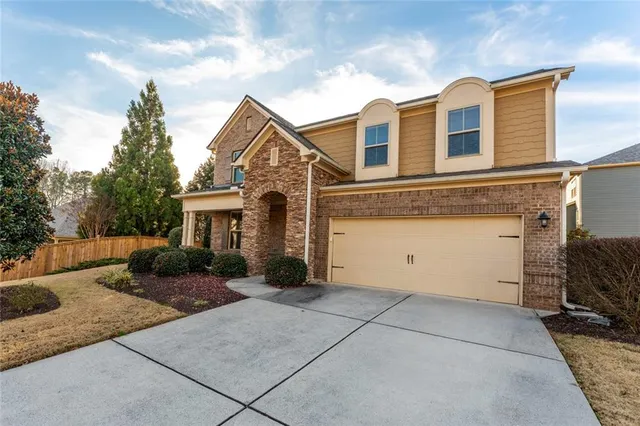 a front view of a house with yard garage and outdoor seating