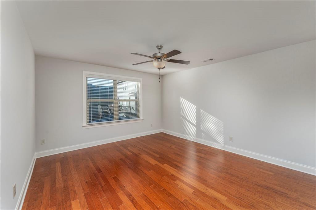 624 East Hampton Place Canton, GA 30115 - Photo 21 of 37 an empty room with wooden floor and windows
