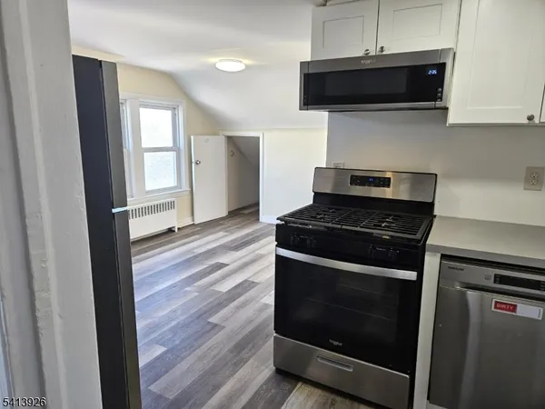 a kitchen with stainless steel appliances a stove a microwave and cabinets