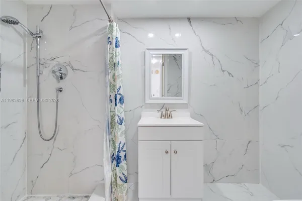 a bathroom with a granite countertop sink a toilet and bathtub