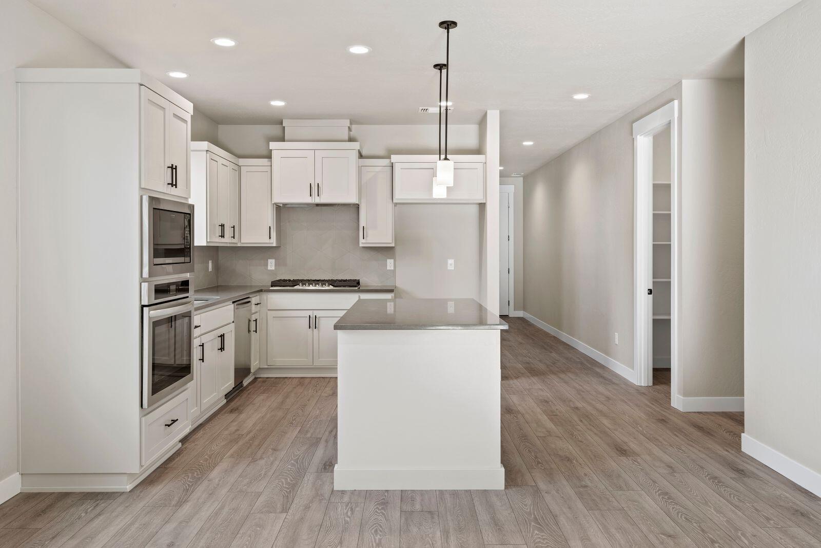 1135 Pumpkin Ridge, Unit 319 Eagle Point, OR 97524 - Photo 11 of 34 a kitchen with stainless steel appliances kitchen island a refrigerator a stove and a wooden floor