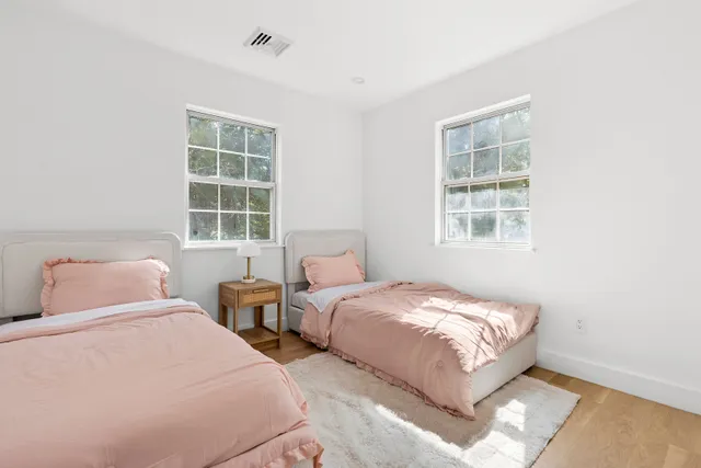 a bedroom with two beds and a window