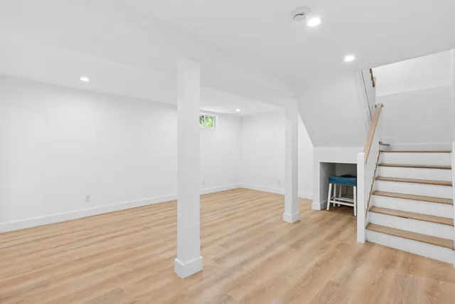 a view of empty room with wooden floor and fireplace