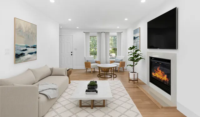 a living room with furniture a flat screen tv and a fireplace