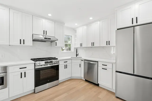 a kitchen with cabinets appliances and wooden floor