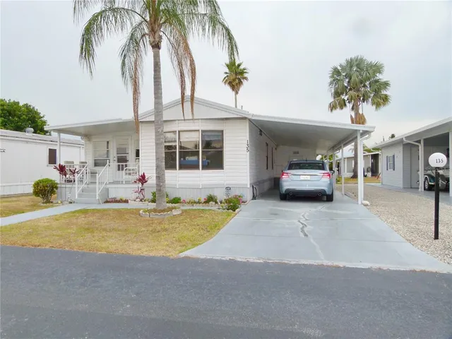 a view of a swimming pool with plants and palm trees