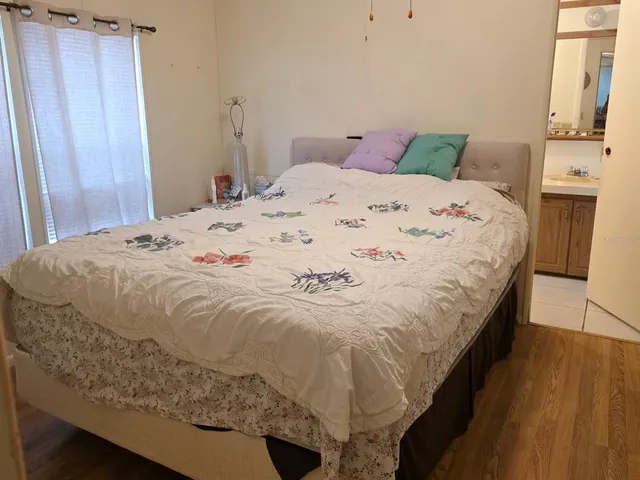 a bedroom with a bed and wooden floor