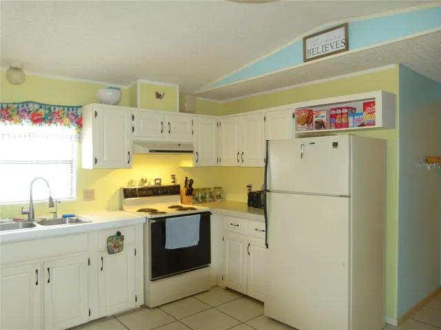 a kitchen with white cabinets and white appliances