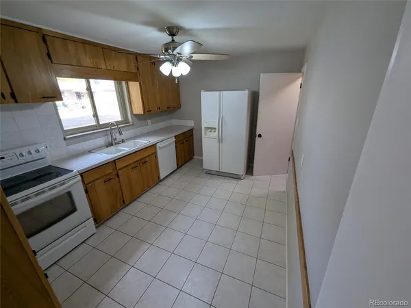 a large kitchen with a stove a refrigerator and a sink