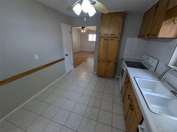 a kitchen with a sink a refrigerator and cabinets