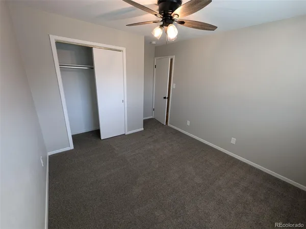 an empty room with a fan and a fan