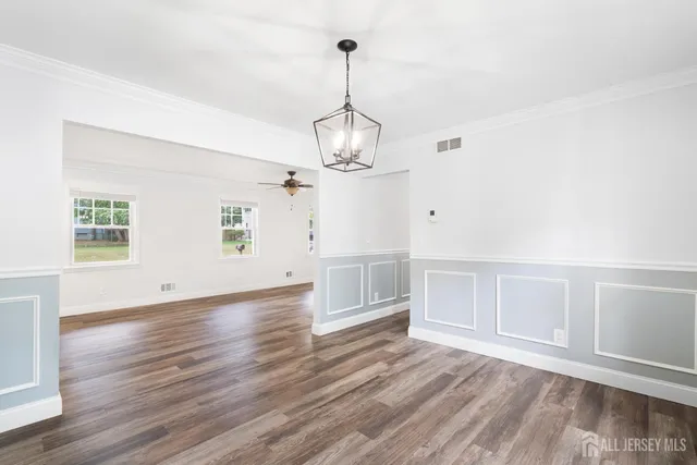 a view of empty room with wooden floor and ceiling fan