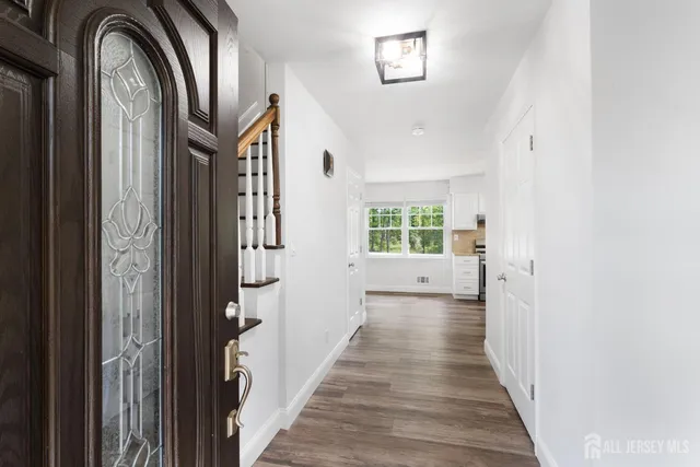 a view of a hallway with wooden floor and staircase