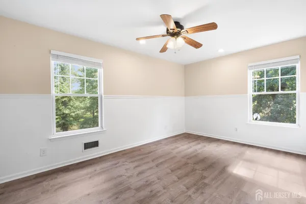 an empty room with window and ceiling fan
