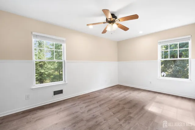 an empty room with window and ceiling fan