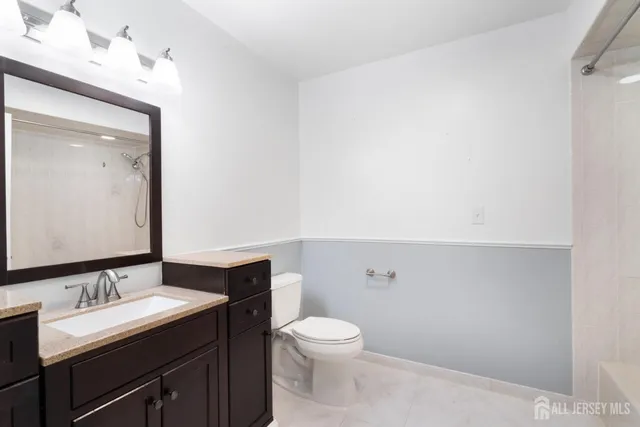 a bathroom with a toilet a sink and mirror
