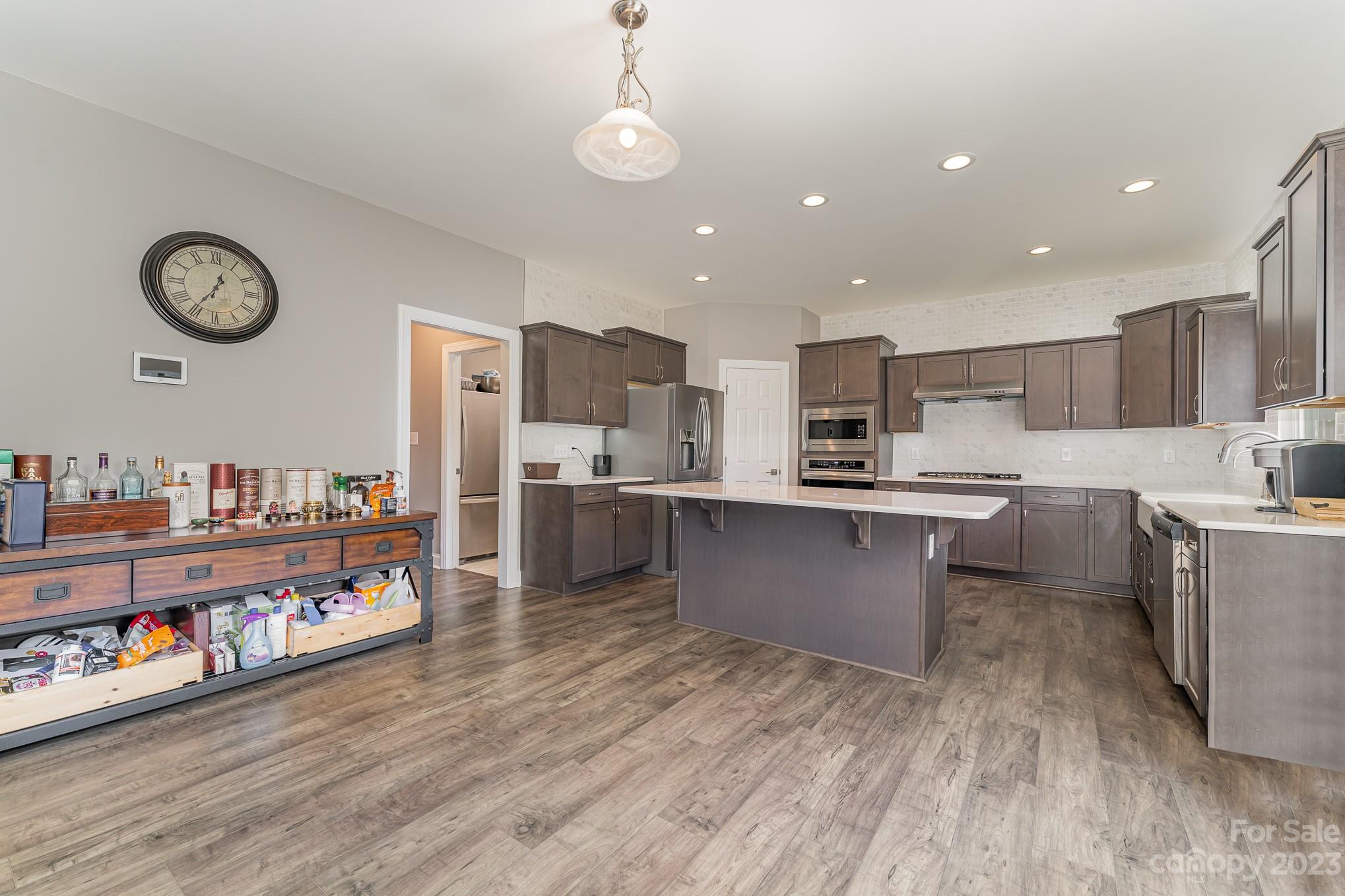 556 Sain Road Mocksville, NC 27028 - Photo 19 of 48 a large kitchen with stainless steel appliances granite countertop a lot of counter space and wooden floor