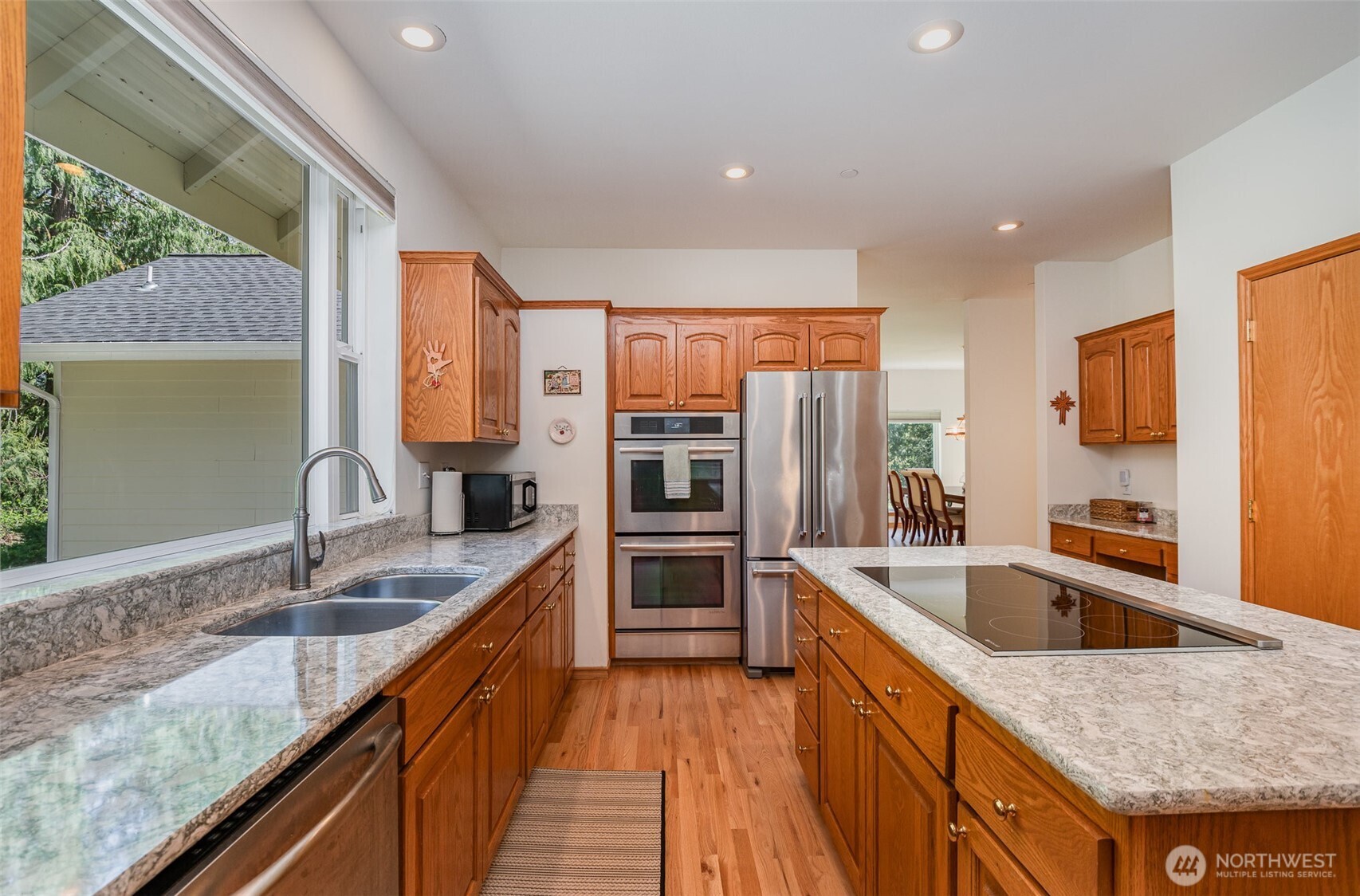 19716 Southeast 220th Street Renton, WA 98058 - Photo 16 of 36 a kitchen with stainless steel appliances granite countertop a sink a stove and a refrigerator