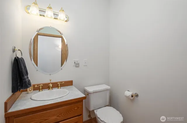 a bathroom with a granite countertop toilet sink and mirror