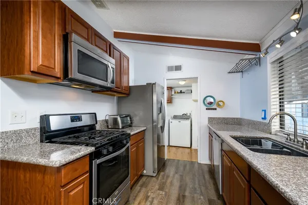 a kitchen with stainless steel appliances granite countertop a sink stove and microwave