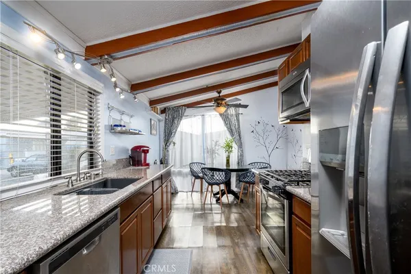 a kitchen with stainless steel appliances granite countertop lots of counter top space and wooden floor