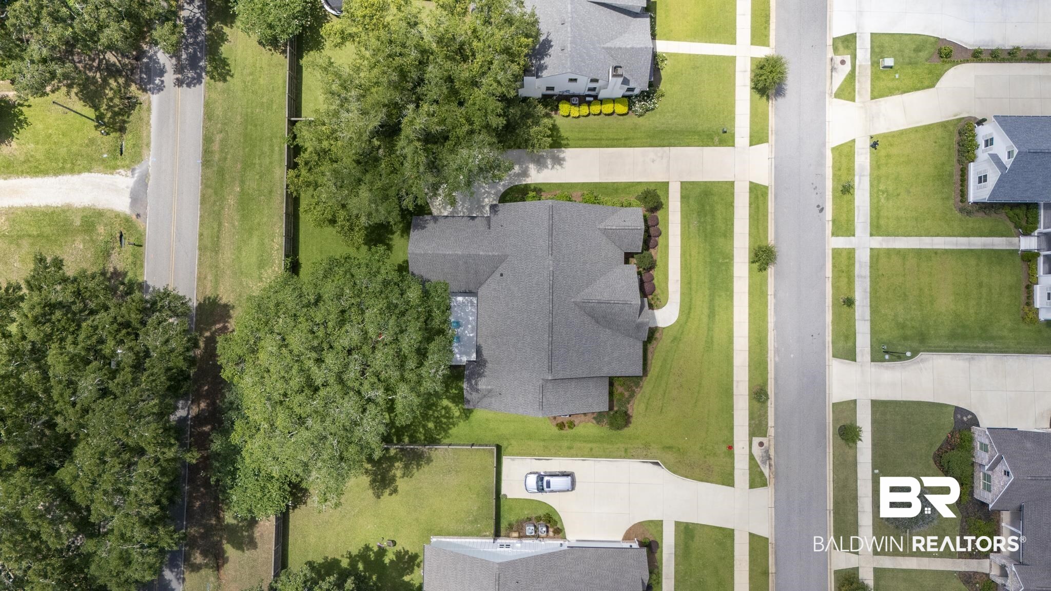 21702 Pillars Street Fairhope, AL 36532 - Photo 47 of 54 Single-family residence with a multi-gabled roofline, featuring a verdant lawn, mature trees, and a paved driveway