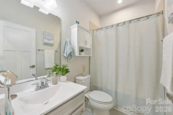 a bathroom with a sink a toilet and shower curtain