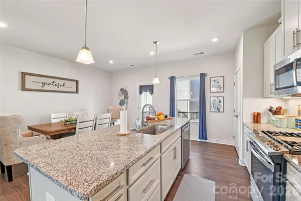 a kitchen with stainless steel appliances granite countertop a stove oven and a counter space