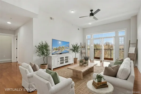 a living room with furniture potted plant and a large window