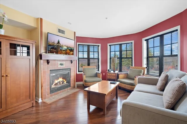 a living room with furniture a fireplace and a large window